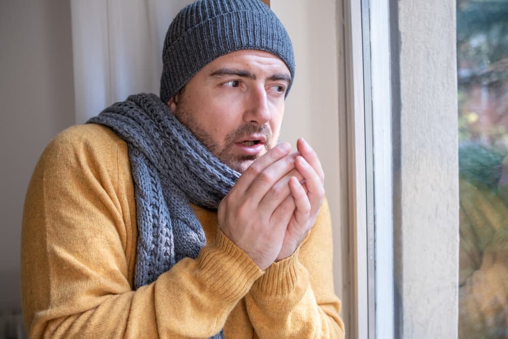 One man feeling cold at home because of furnace problems