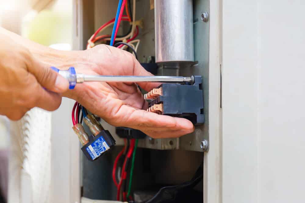 Close up of repairman installing magnetic contactor and fixing HVAC system