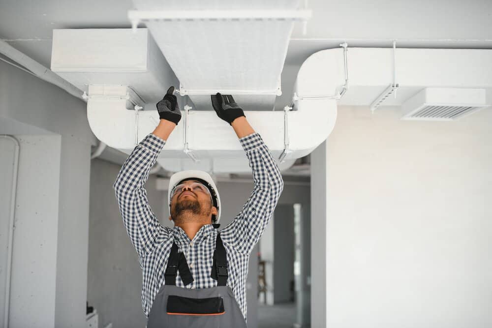 hvac services worker install ducted pipe system for ventilation and air conditioning in house.