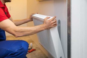 man installing room heater on the wall
