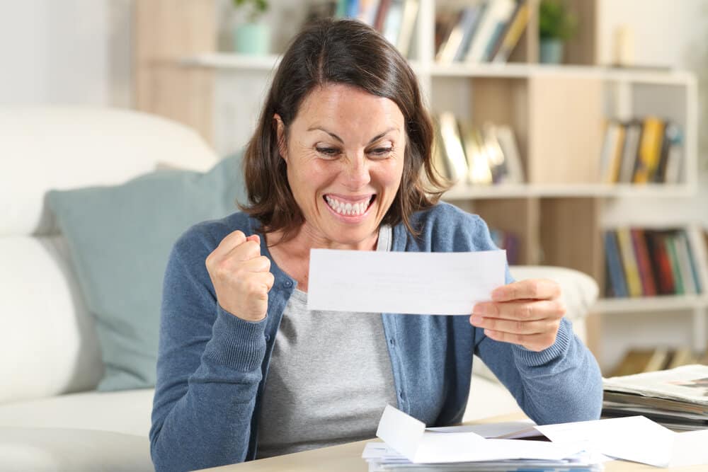 Excited adult woman celebrating a rebate check
