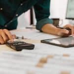 Close up of contractor pressing on calculator for estimating