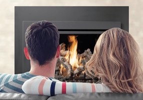 Couple Sitting By A Gas Fireplace