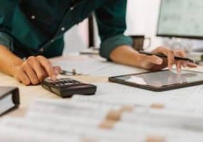 Close up of contractor pressing on calculator for estimating