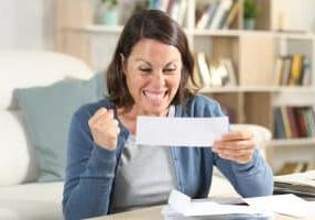 Excited adult woman celebrating a rebate check