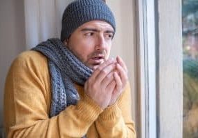 One man feeling cold at home because of furnace problems
