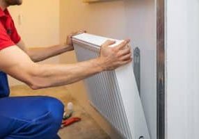 man installing room heater on the wall