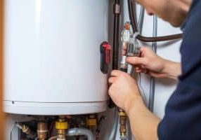 Technician repairs an electric water heater in a house